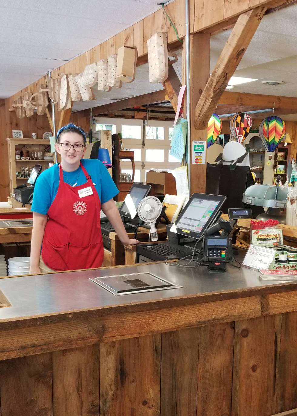 Point of Sale at Destination Farmer's Markets, with and employee standing next to it facing the camera