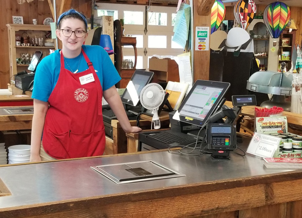 Point of Sale at Destination Farmer's Markets, with an employee standing next to it